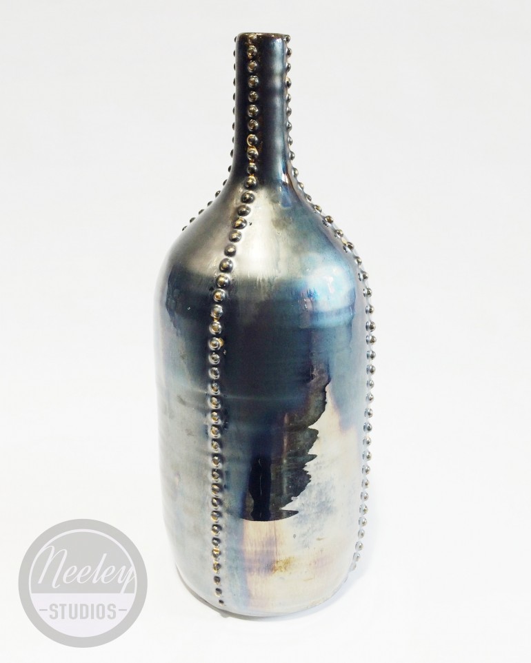Studded vessel with palladium glaze and gold lustre.  The two glazes layered together created an oily look.